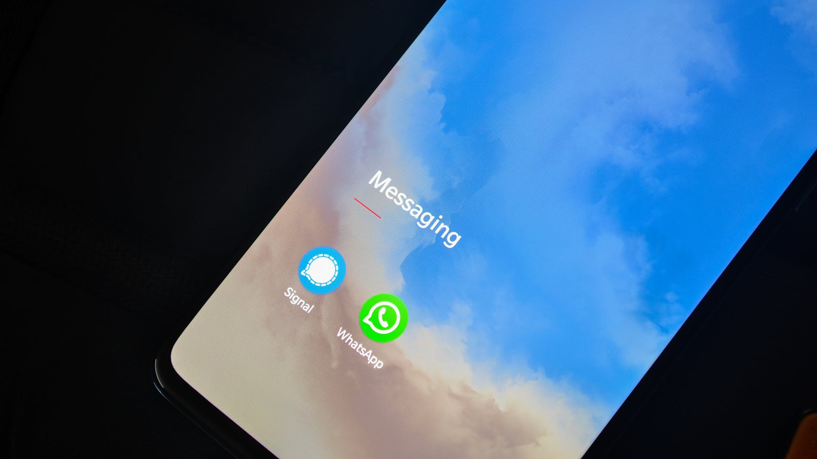 Gülümseyen bir adam elinde bir telefon tutuyor, etrafında internet ve sohbet simgeleri var