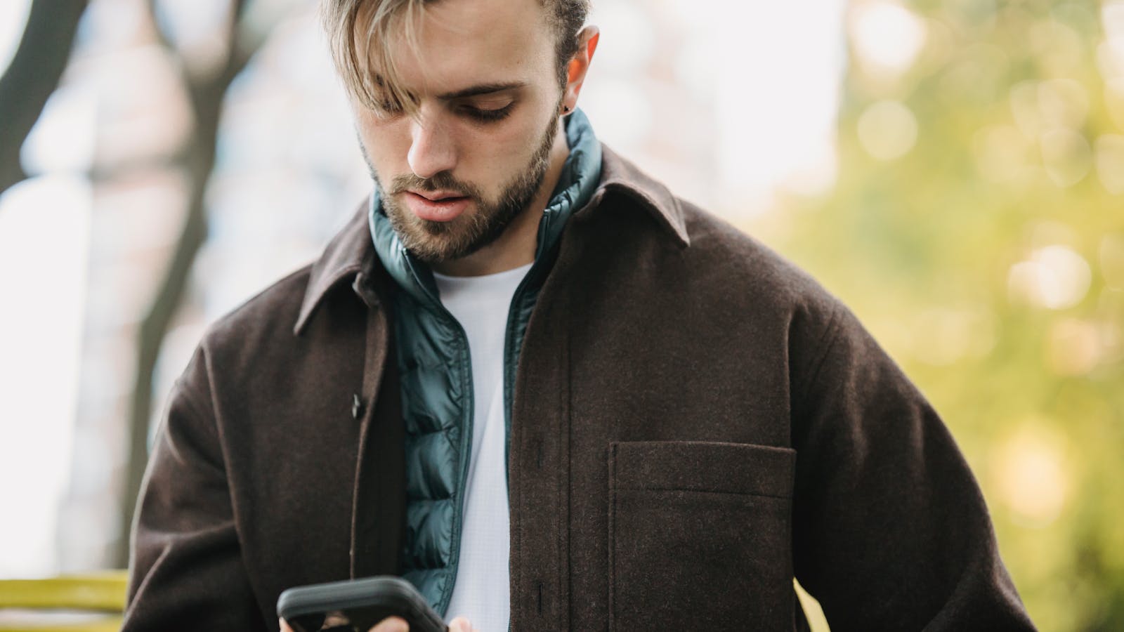 Birinin elindeki telefonun ekranında WhatsApp simgesi ve chatbot servis sağlayıcısının logoları